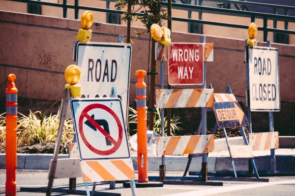 A photo of road blocks, wrong way signs, road closed signs, and detour signs.