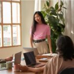 A young woman speaks to two people about her idea.