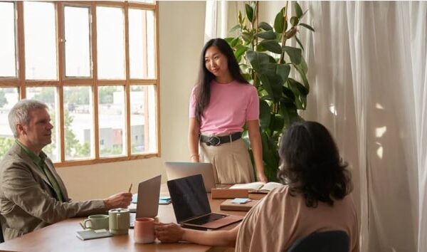 A young woman speaks to two people about her idea.