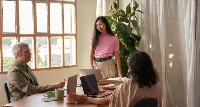 A young woman speaks to two people about her idea.