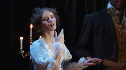 A young actress sings onstage.