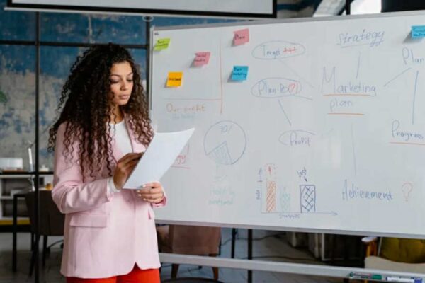 A woman standing in front of a whiteboard.