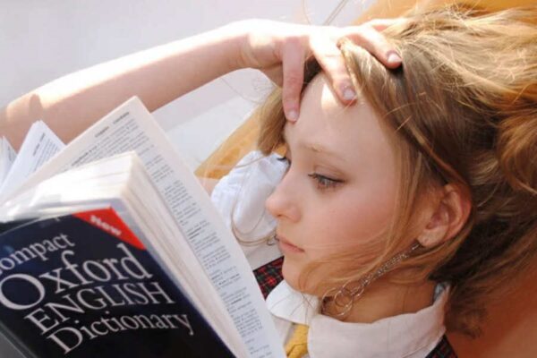 A young girl studies the dictionary.