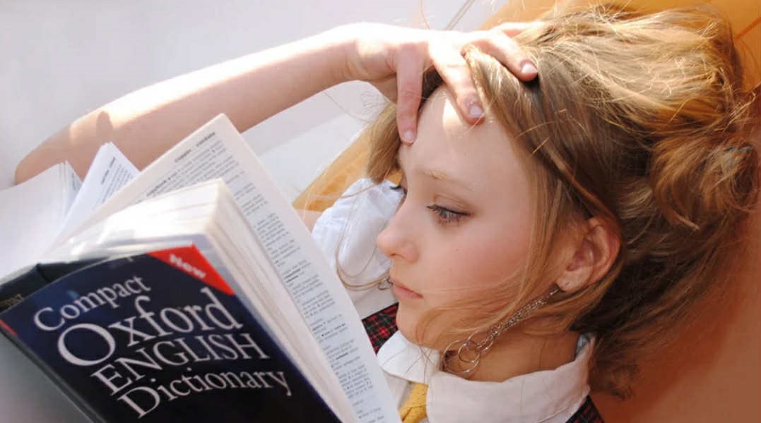 A young girl studies the dictionary.