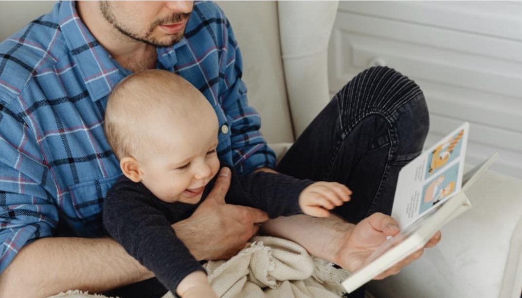 A father and child read a book.