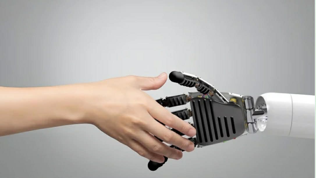 A human hand and a robotic hand reaching toward one another.